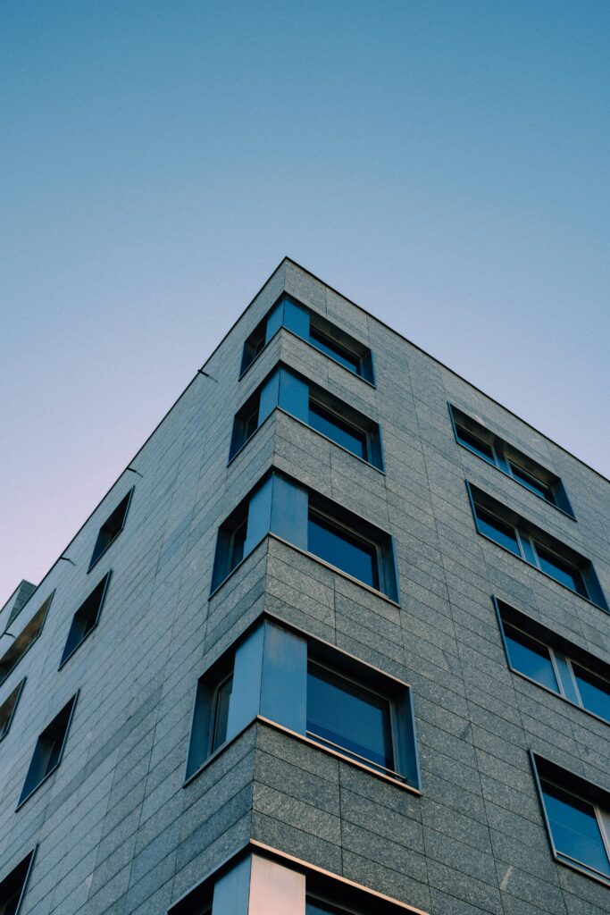 Low angle view of a modern apartment building with large windows against a clear sky.